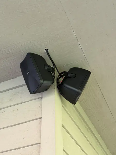 Pair of outdoor speakers mounted under a roof overhang